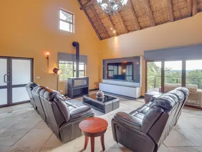 a living room with leather couches and a tv at 210 Zebula, 5-bedroom villa in Warmbaths