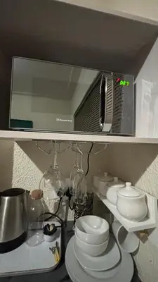 a shelf with a mirror and a bunch of dishes at Harmony Spaces in Kempton Park