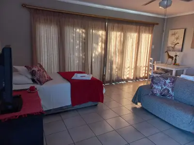 a living room with a bed and a couch at 109 Mauser Avenue in Pretoria