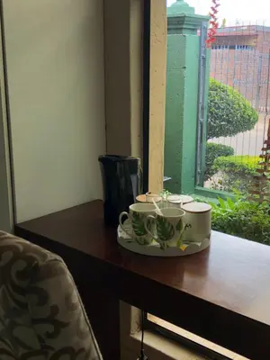 a table with two coffee cups and a window at Urban Space Lodge in Pretoria