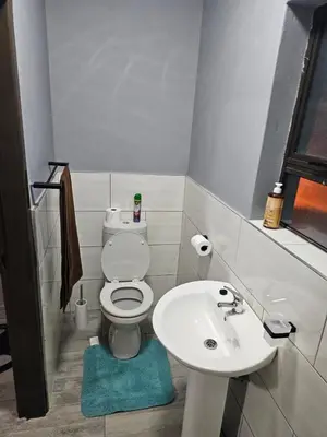 a small bathroom with a toilet and a sink at Beautiful apartment in Witbank