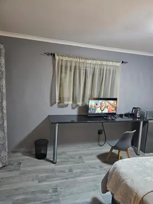 a desk with a computer on it in a bedroom at Beautiful apartment in Witbank