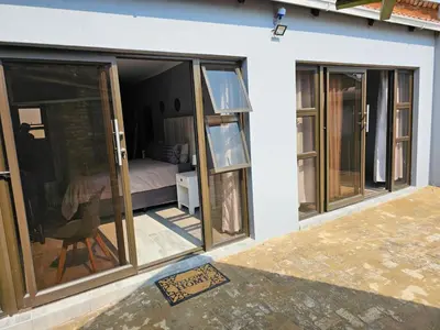 a room with sliding glass doors and a bedroom at Beautiful apartment in Witbank