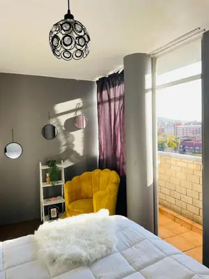 a bedroom with a bed and a yellow chair at Cloud 10 Hideaway in Pretoria