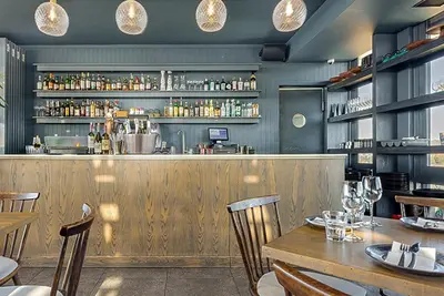 a restaurant with a wooden bar with tables and chairs at Menlyn Maine Luxury Studio King Bed Free parking 133 in Pretoria