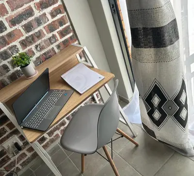 a desk with a laptop and a chair at Double Bed in the Capital City in Pretoria