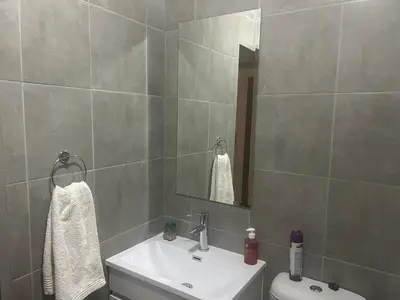 a bathroom with a sink and a toilet and a mirror at Two Bedrooms in the Capital City in Pretoria
