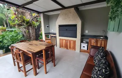 a living room with a wooden table and a television at Upstairs R-3 Self Catering Unit in White River