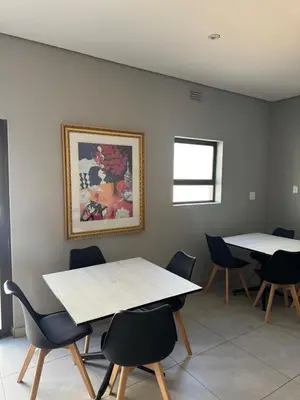 a room with two tables and chairs and a picture on the wall at Glowti Event & Guest House in Centurion