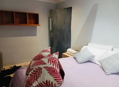 a bedroom with a white bed with pillows on it at The Chardonnay Inn in Centurion