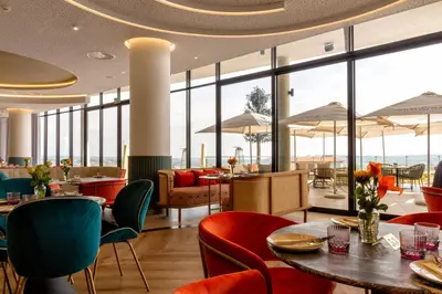 a restaurant with tables and chairs and large windows at #AlimamaSpaces The Chelsea's Cassini Ellipse in Vosburg