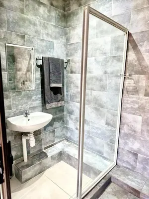 a bathroom with a shower and a sink at Glow Events & Guest House in Centurion