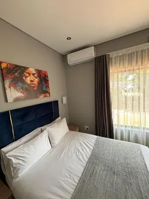 a bedroom with a white bed and a window at Glowti Event & Guest House in Centurion