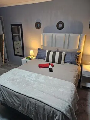 a bedroom with a large bed with a red towel on it at Lanico in Witbank