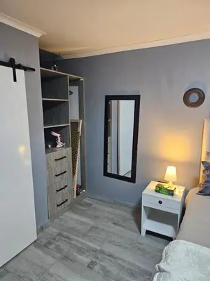 a bedroom with a bed and a table and a mirror at Lanico in Witbank