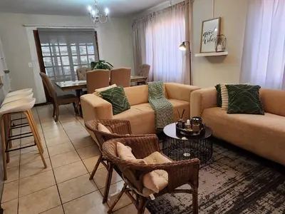 a living room with a couch and chairs and a table at Pearl Palace in Polokwane