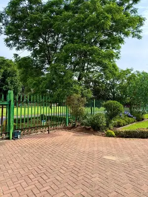 a park with a fence and a tree and a bench at Cosy retreat for 2 at MeadWay in Benoni