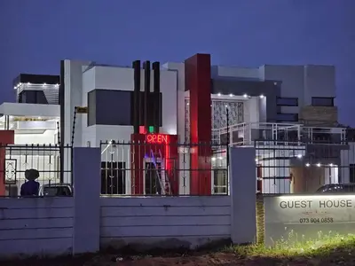 a building with a guest house at night at turfloop guest house in Mankweng