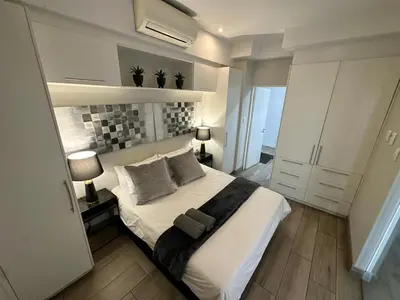 a bedroom with a large white bed with two pillows at Stay Menlyn - Luxe Apartment 617 in Pretoria