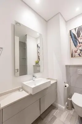 a white bathroom with a sink and a toilet at 132 Menlyn Maine in Pretoria