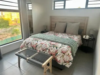 a bedroom with a bed and a bench in it at Business trip or Fun with the Family - you decide! in Pretoria