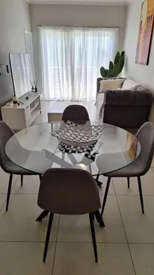a living room with a glass table and chairs at The Perfect Luxury Space at 93 on new in Midrand