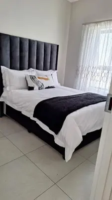 a large bed with a black headboard in a bedroom at The Perfect Luxury Space at 93 on new in Midrand