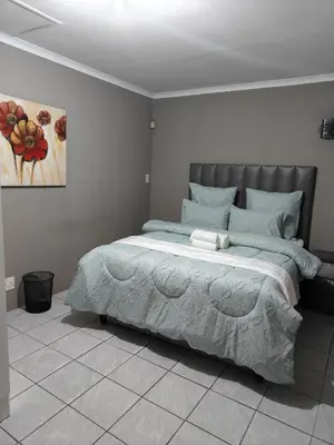 a bedroom with a large bed in a white room at Tranquil Accommodation in Midrand