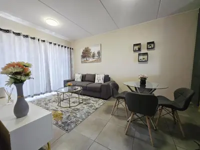 a living room with a couch and a table at Nat's Villa in Midrand