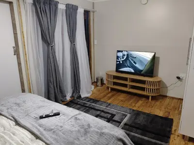 a bedroom with a bed and a flat screen tv at The Man Cave Extension in Sabie