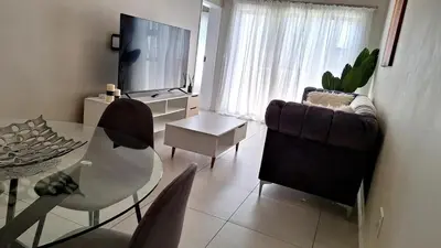 a living room with a glass table and a television at Elegant & Timeless at 93 on new in Midrand