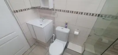 a white bathroom with a toilet and a sink at 329 on 30th Avenue Villieria Justin in Pretoria
