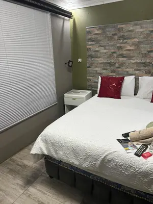 a bedroom with a large bed with red pillows at Lakeboutiquehotel empire new in Thohoyandou