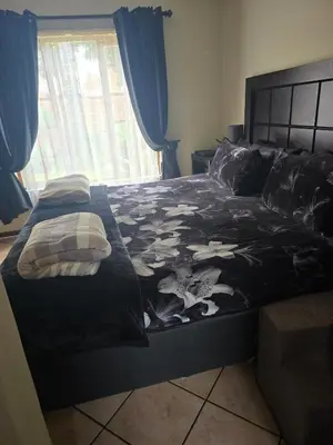 a bed in a bedroom with a black comforter at Entire Home - Relax - Work - Entertain - Private in Centurion