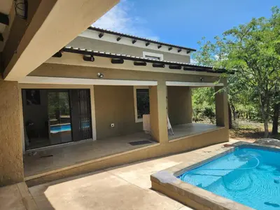 a swimming pool in front of a house at Neotha Villa Unit 1 in Marloth Park