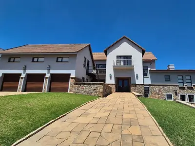 a large white house with a brick driveway at Highlands Retreat Lodge In Highland Gate Golf and Trout Estate 1135 in Dullstroom