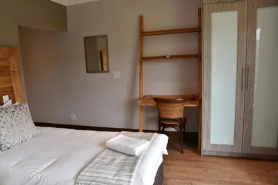 a bedroom with a bunk bed and a desk at Highlands Retreat Lodge In Highland Gate Golf and Trout Estate 1135 in Dullstroom