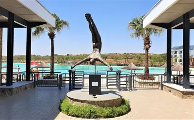 a statue of a dinosaur next to a pool at 2 Bed Lux apartment at The Blyde in Pretoria