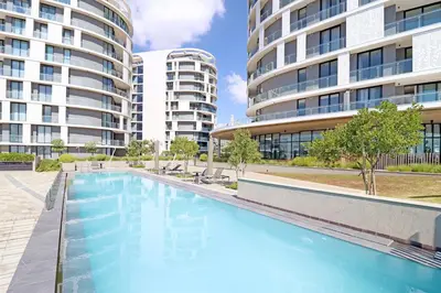 a swimming pool in front of two tall buildings at Thango Executives Gallileo Ellipse in Midrand