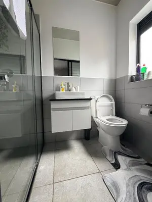 a bathroom with a toilet and a sink and a shower at Sunset Sucasa in Midrand