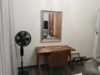 a room with a table and a mirror and a fan at Melkbos Corner in Witbank