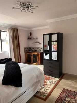 a bedroom with a bed and a dresser and a mirror at MorningMist Boutique 27 Dawie de Villiers Room 3 in Centurion