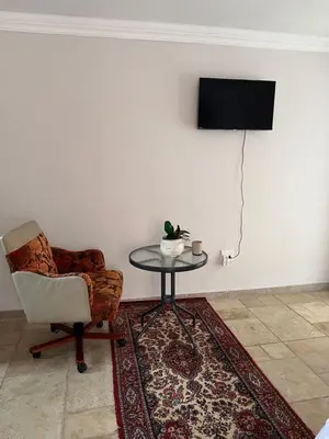 a room with a chair and a table and a television at MorningMist Boutique 27 Dawie de Villiers Room 3 in Centurion