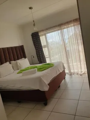a bedroom with a bed and a large window at The Blyde resort in Pretoria