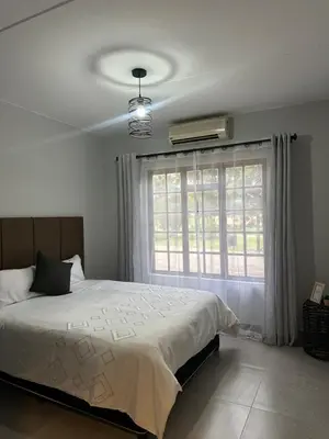 a bedroom with a large bed and a window at Pendleberry Grove 33 in Bela-Bela