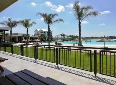 a view of the pool at a resort with palm trees at Cosy stay at The Blyde With Lagoon in Pretoria