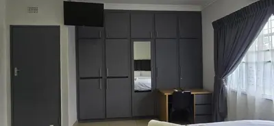 a bedroom with a large cabinet with a television on it at Good night guest house in Polokwane