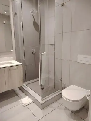 a bathroom with a shower and a toilet and a sink at Menlyn Maine Trilogy Apartment 106 in Pretoria