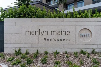a sign for a manhattanamineresbestosbestosccess at Menlyn Maine Trilogy Apartment 106 in Pretoria