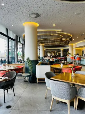 a restaurant with tables and chairs and a cafeteria at Elegant Ellipse Waterfall Luxury with Gym, Spa & Dining in Midrand